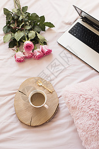 粉红色床单上的玫瑰笔记本电脑和智能手机 平躺风格的自由时尚家居女性气质工作区女孩房间教育互联网技术酒店电话博主生活相机背景图片