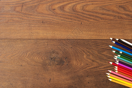 棕色木桌背景上的彩色铅笔 彩色铅笔框架在木头上 带有文本复制空间的可用空间办公室艺术蓝色团体光谱工具创造力大学蜡笔染色背景图片
