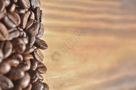 左侧浅色木质背景上漂亮的油炸咖啡豆背景图片