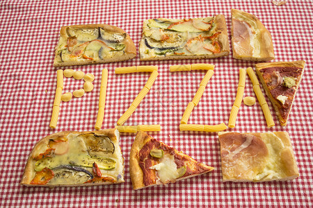 披萨片环绕着用意大利面做成的写作素食主义者火腿蔬菜高清图片