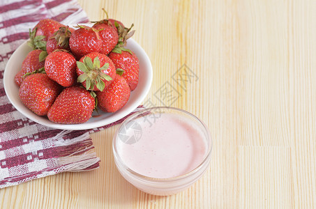 大草莓放在碟子上 站在木板桌上背景图片