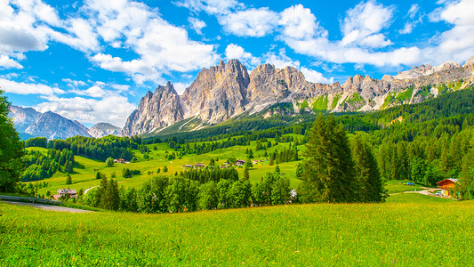 意大利多洛米蒂山 科尔蒂纳丹佩佐上方的山的岩石山脊 绿草如茵 蓝天白云高山顶峰森林山脉晴天旅行国家水饺假期全景背景