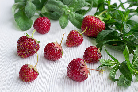 红草莓 白木上绿色新鲜鲜薄荷草药草背景图片