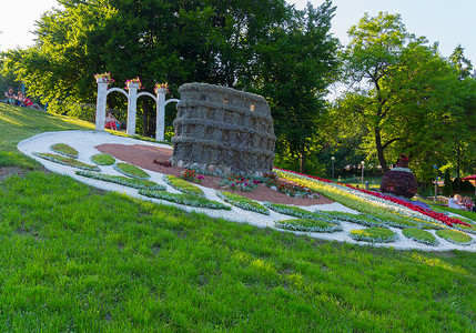 制作花坛素材坐在山坡顶上公园的观光游客想象着 在花盆中间雕塑 以堡垒的形式制作了一座雕像背景