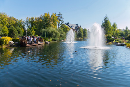 公园喷泉蓝色装饰湖上一个木制观察甲板 配有几个背景