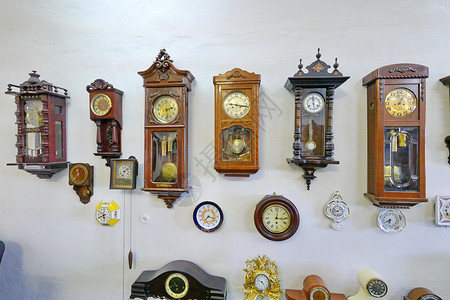 老墙上时钟墙上布着大量完全不同的时钟装置 安装在一堵墙上背景