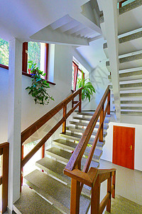 走廊窗户在旅馆建筑群走廊内有木栏杆的石楼梯 在楼层背景