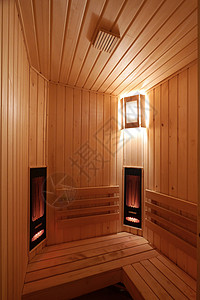 一个用木头和一面墙灯的柔光挂着一盏墙灯的桑拿室背景图片