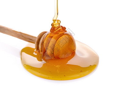 带蜂蜜的木制蜂蜜勺子液体糖浆黄色食物白色背景图片