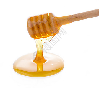 带蜂蜜的木制蜂蜜白色糖浆勺子食物黄色液体背景图片