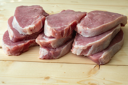 木制板上的新鲜原生猪肉片背景图片