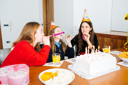 吹熄参加生日派对的儿童孩子们帽子女孩们桌子周年快乐小吃眼镜幸福纪念日背景