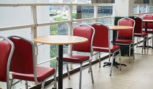 大学食堂座位高楼空的红椅和圆木板桌背景