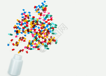 将抗生素胶囊药丸倒入白色背景的塑料瓶中 并带有复制空间 药品储存 抗生素用药合理 卫生政策和医保理念 医药行业 药房背景背景图片