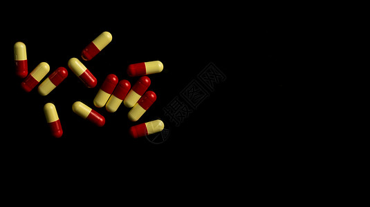 在深色背景上的 Redyellow 胶囊药丸 抗菌素耐药性概念 医药行业 药学背景背景图片