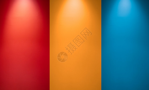 带聚光灯的空红色 橙色或黄色和蓝色墙壁 照明灯灯 与吸顶灯光和五颜六色的墙壁的屋子内部 工作室墙纹理背景背景图片