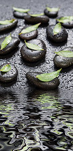 黑色石块和绿叶 被水滴覆盖涟漪温泉石板波浪风水按摩卫生卵石植物宏观背景图片