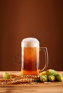大麦啤酒特写啤酒杯 酒杯和大麦白色棕色泡沫状小麦桌子黄色草稿啤酒茶点酒花背景