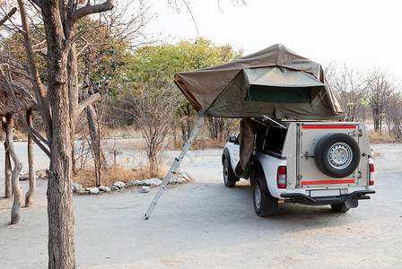 4x4号越野车 屋顶有帐篷冷却器红色越野桌子露营者乡村椅子运输睡袋沙漠背景图片