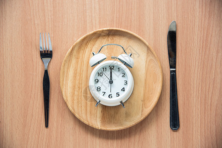 中午12点的时钟是用木制餐具吃午饭手表展示唤醒午餐勺子卧室小时倒数警报苏醒背景