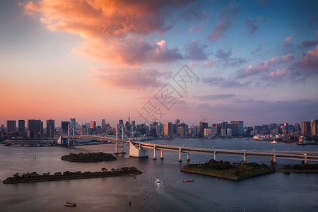 东京湾日本日落时与东京塔和彩虹桥的东京天际线背景