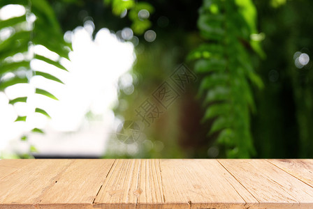 深色树叶抽象模糊背景前的深色木桌图像公园嘲笑木头森林晴天墙纸柜台产品乡村桌子背景
