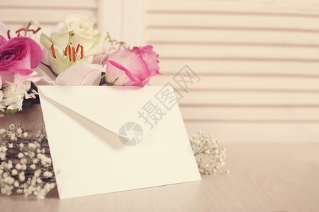 百合玫瑰花篮和信封百合邀请函调子邮件礼物邮政问候语卡片玫瑰木头背景