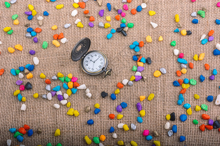 彩色鹅卵石中的怀表手表倒数矿物商业宝石小时卵石岩石宏观碎石背景图片