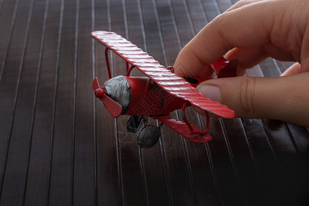 手持玩具飞机在木质纹理上世界航空公司旅行航班运输商业喷射乘客白色车辆背景图片