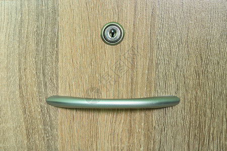 带一个钥匙孔的棕色木壁柜抽屉背景图片