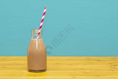 巧克力奶昔 在玻璃瓶里加一个复古稻草背景图片