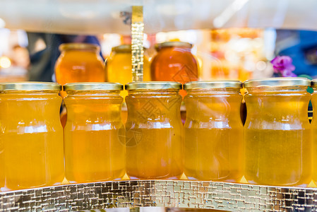 蜂蜜销售素材配有自制有机蜂蜜的罐子出售店铺食物分销商产品棕色液体杂货店营养消费者黄色背景