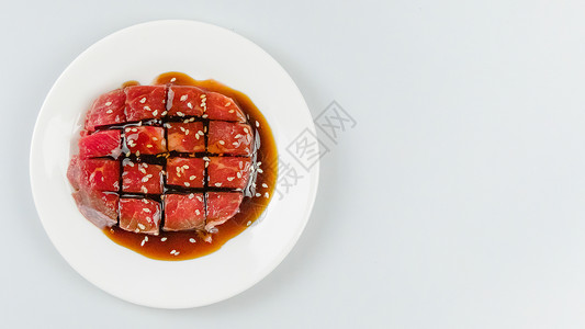 盘子上的生牛肉白色美食奶牛鱼片菜单红色粉色猪肉食物午餐背景图片