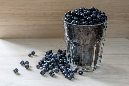 蓝莓装在玻璃杯中 零散的浆果 早餐加好背景