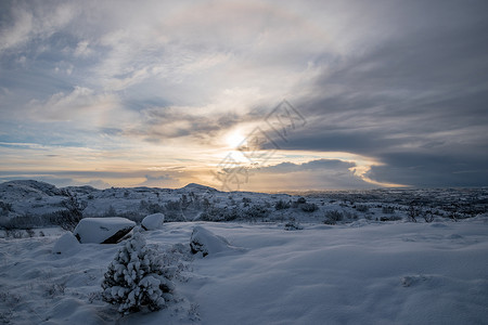 冬季日落时深雪地貌背景图片