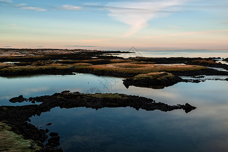 艾斯特劳姆冰岛的Straumur日落旅游农村绿色石头蓝色天空风景红色水平旅行背景