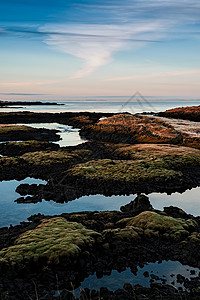 艾斯特劳姆冰岛的Straumur日落旅游绿色蓝色石头天空农村风景旅行红色背景