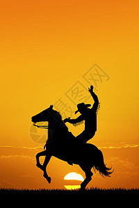 日落时的竞拍牛仔男人动物马背插图荒野鬃毛背景图片