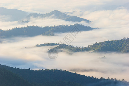 雾在清晨和日落之间沿着山上移动高清图片
