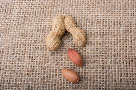 花生碎裂 罐壳夹在麻布上小吃营养坚果种子养分食物饮食背景图片