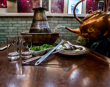 传统的中国热锅 有肉和调味料享受羊肉煮沸食物火锅烹饪家庭桌子盘子蒸汽背景图片