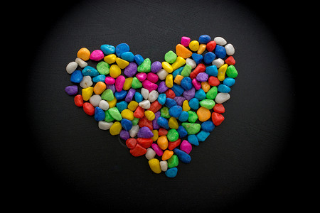 色彩多彩的小卵石形成心脏形状鹅卵石红色礼物粉色热情背景图片