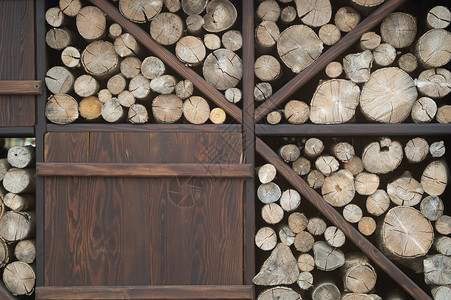 木质木桩堆在咖啡厅墙附近 装饰和美丽的物品松树环境产品森林林业心材木头库存记录柴堆背景图片