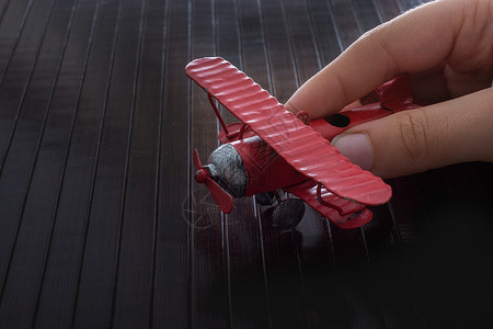 手持玩具飞机在木质纹理上乘客车辆航班旅行喷射运输白色航空公司商业世界背景图片