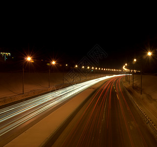 夜间光反射从经过的汽车前灯发出的光迹 这张照片是在夜间长时间曝光拍摄的速度小路城市灯笼运动旅行大灯反射运输车辆背景