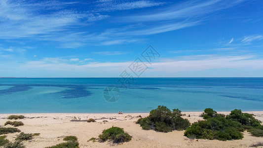 皮尔巴拉坐在西澳大利亚州鲨鱼湾空海滩上的年轻夫妇人数背景