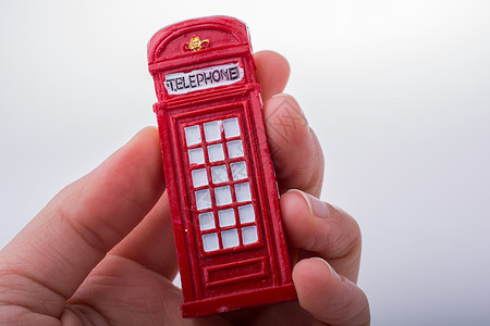 手持白色背景的电话亭 手持电话公用电话盒子城市红色英语背景图片