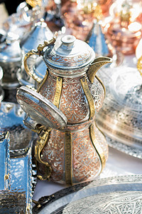 东方风格的古金属罐水壶金属壶金子厨房投手黄铜古董背景图片