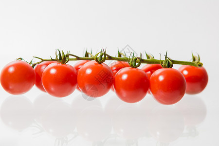 在白色背景下喷出樱桃番茄背景图片