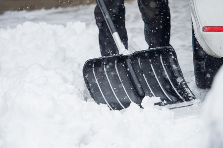 有人在冬雪下雪的时候 正在外面铲雪呢运动船运雪衣手套天气白色冻结场景衣服雪人背景图片